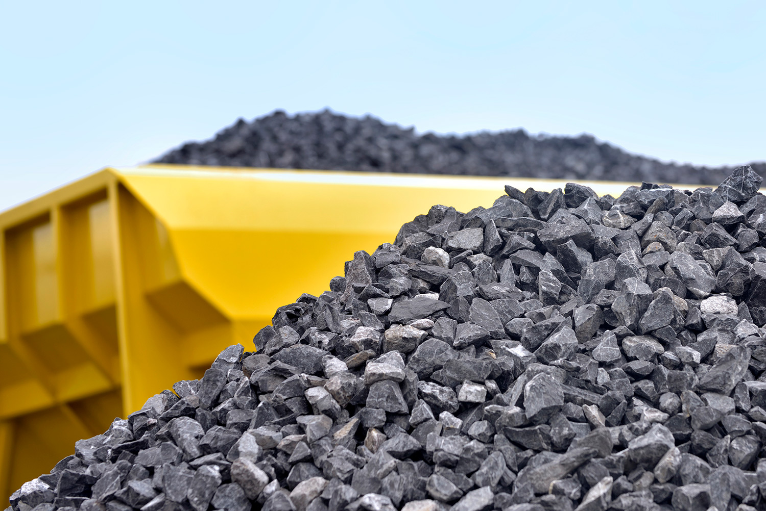 Pile of crushed stone behind a yellow truck