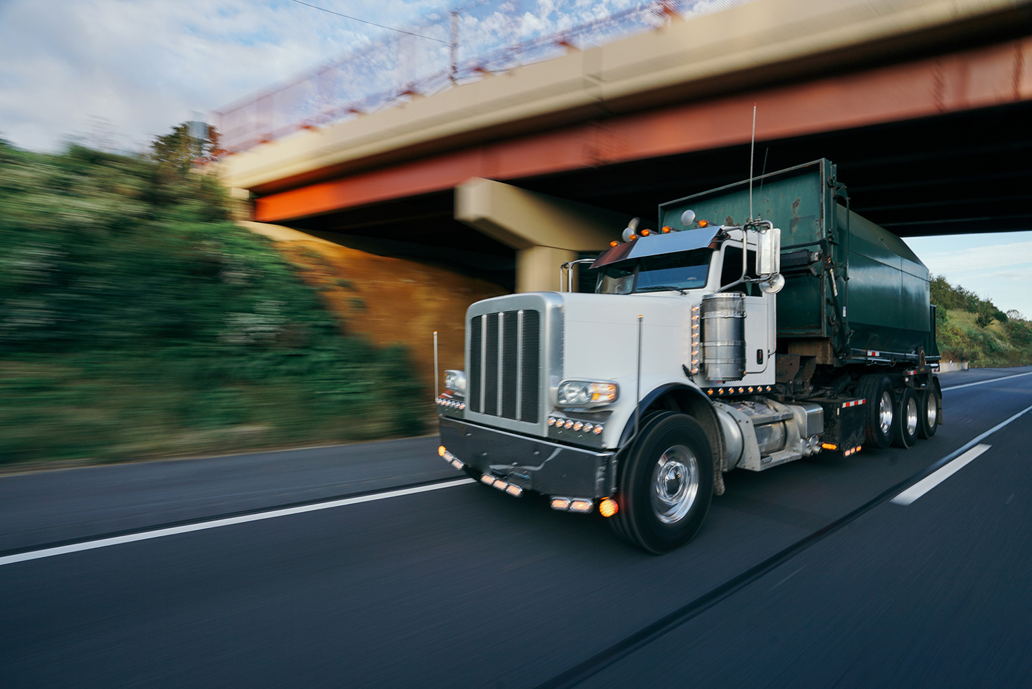 Garbage truck on highway stock photo.