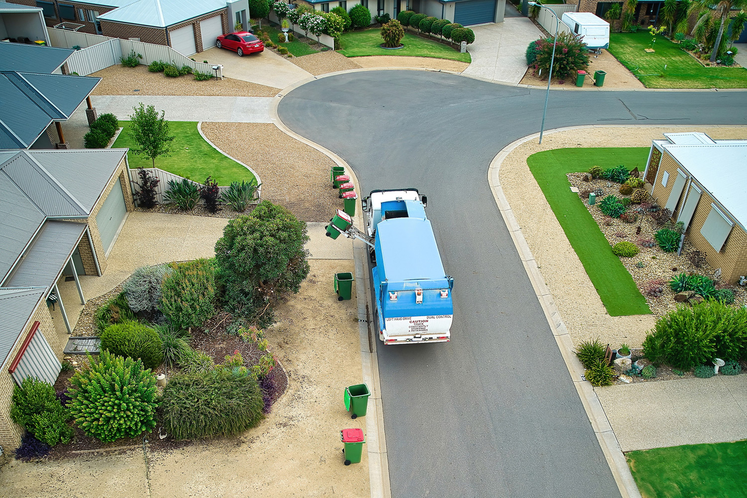 Garbage truck picking up waste in a residential neighborhood